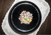 Exceptional 14.91ct Colombian emerald displayed among pastel candies on a black plate